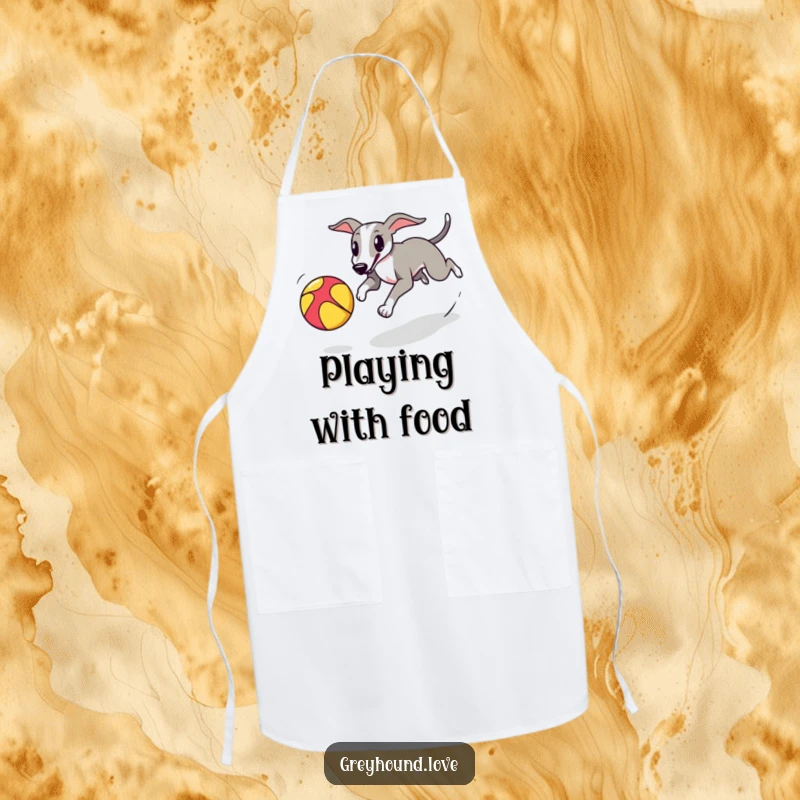 A greyhound playfully chasing a colorful bouncing ball is printed on a kitchen apron for active cooks.