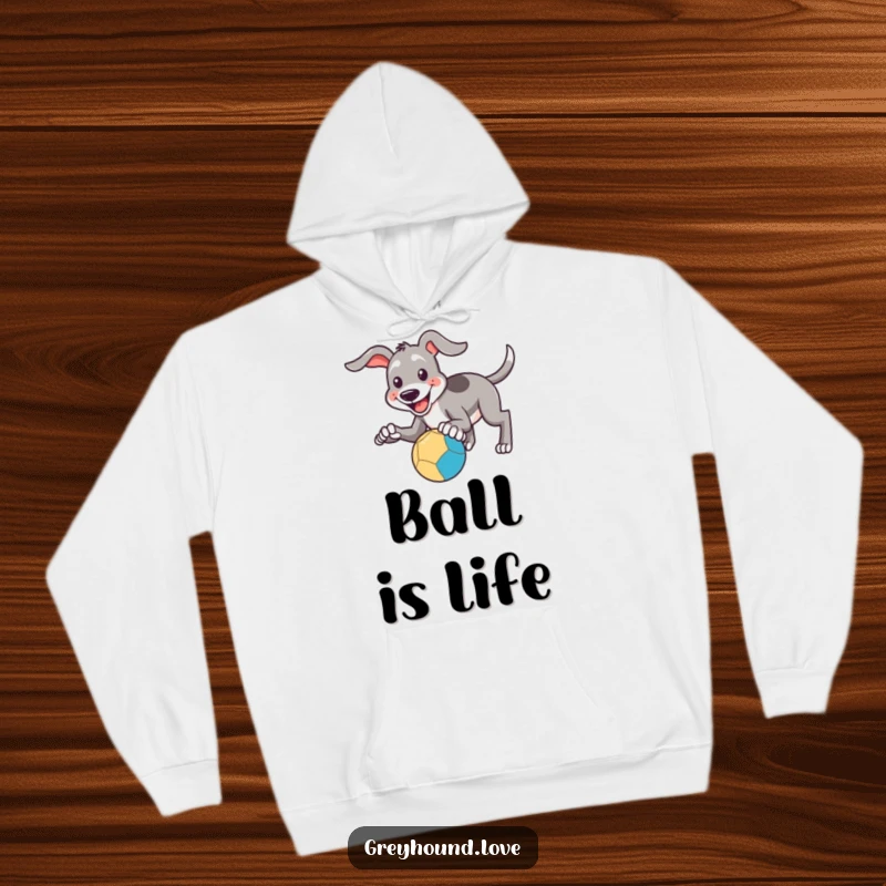 Funny Hoodie: A greyhound with a smile attempts to catch a bouncing ball with its paws, looking ready for fun.